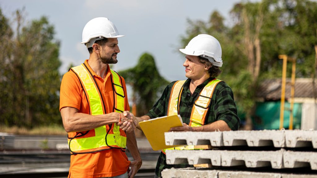 Construction workers shake hands after a deal.