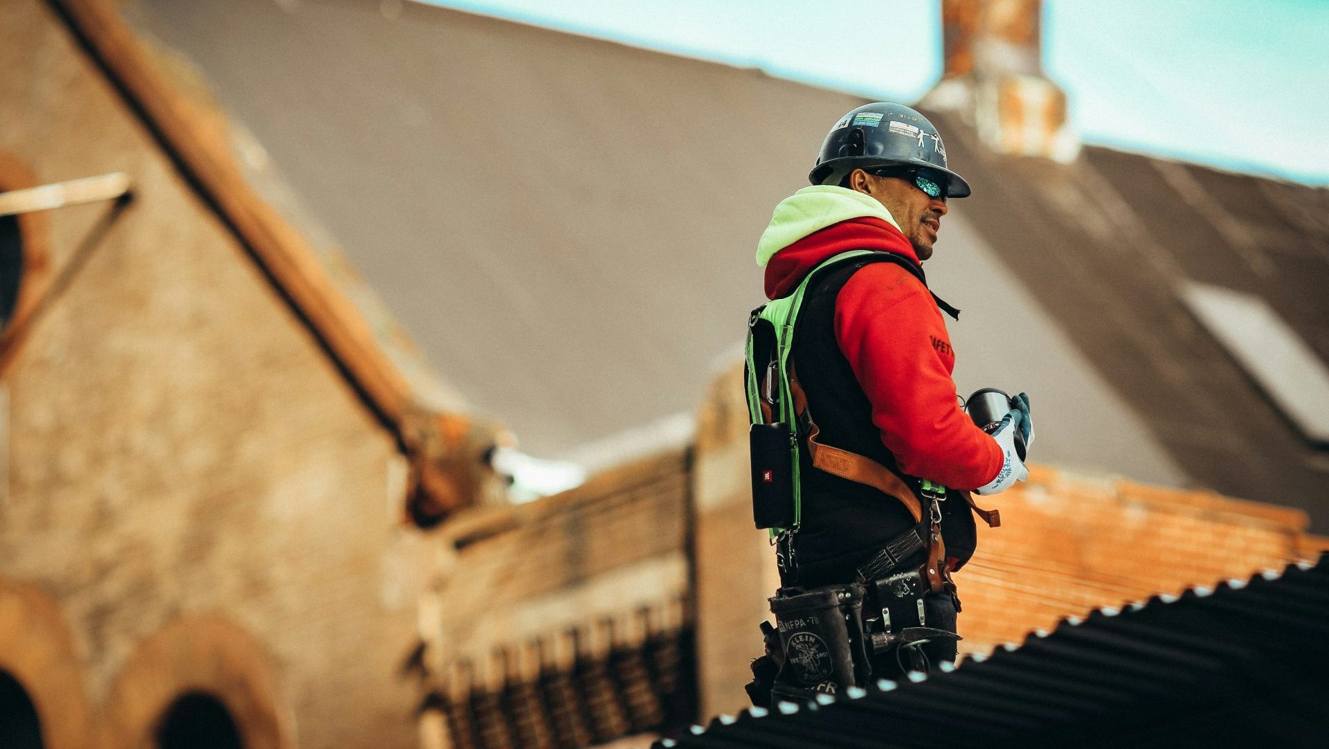 man in black helmet and red and black jacket standing on brown concrete stairs during daytime