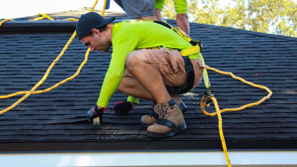 two men working on the roof of a house